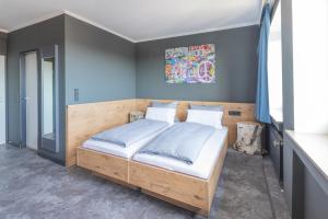 a bedroom with a large bed with blue walls at Hotel Mecklenheide in Hannover