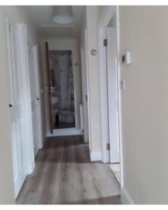 an empty hallway with white walls and wooden floors at The Maltings - Apartments 1 in Shepton Mallet