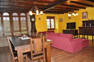 sala de estar con mesa y sofá rosa en APARTAMENTOS RURALES CASTRO DE VILAOSENDE en Ribadeo