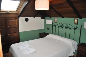 a bedroom with a bed with two towels on it at APARTAMENTOS RURALES CASTRO DE VILAOSENDE in Ribadeo