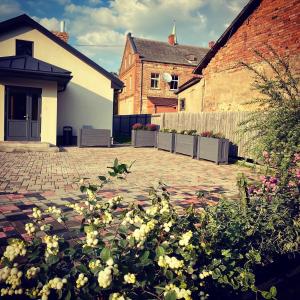 a courtyard with some flowers in front of a house at Pilsētas Māja- guest house in Dobele city center in Dobele