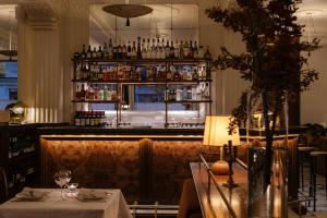 a restaurant with a bar with a table and a counter at Hotel Rochechouart - Orso Hotels in Paris