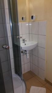 a small bathroom with a sink and a shower at Pokoje Gościnne "U Karola" in Ścinawa