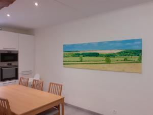 una cocina con una mesa y una pintura en la pared en Les gîtes du Broukay - Alouette, en Bassenge