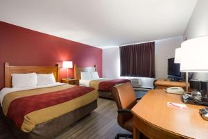 a hotel room with two beds and a desk at Econo Lodge Inn & Suites in Escanaba