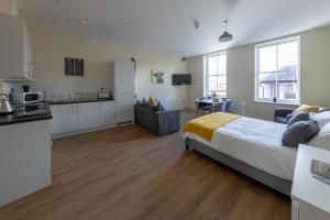 a bedroom with a large bed and a kitchen at Hereford City Centre - Apartment 6, Isabella House - Modern Apartment In The Heart of The City - Sleeps 4 Guests - Hosted by RENTMYHOUSE in Hereford