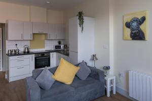 uma sala de estar com um sofá e uma cozinha em Apartment 6, Isabella House, Aparthotel, By RentMyHouse em Hereford