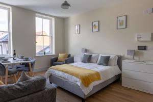 um quarto com uma cama, uma mesa e cadeiras em Apartment 6, Isabella House, Aparthotel, By RentMyHouse em Hereford