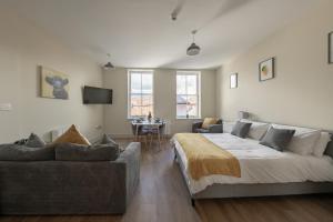 a bedroom with a bed and a couch and a table at Apartment 6, Isabella House, Aparthotel, By RentMyHouse in Hereford