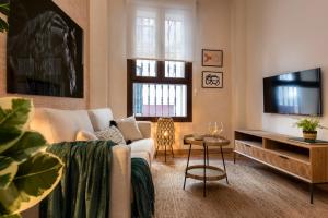 a living room with a couch and a tv at MH Apartments Central Sevilla in Seville