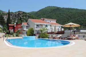 una piscina en un complejo con una montaña en el fondo en Monte Aria panorama suites en Herceg-Novi