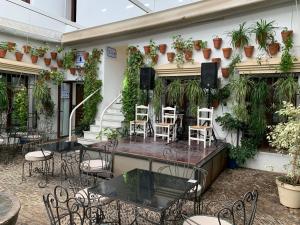 an outdoor patio with tables and chairs and plants at Hotel La Chiquita in Córdoba