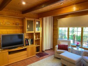 a living room with a flat screen tv in a wooden house at Caseta de Fusta in Aiguafreda