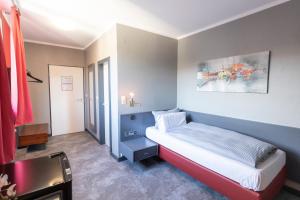 Hotel Mecklenheide في هانوفر: غرفة نوم صغيرة مع سرير وطاولة
