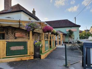 a building with flowers on the front of it at Greyhound Inn in Winterborne Kingston