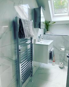 a white bathroom with a sink and a mirror at The Clachan Flat in Rosneath