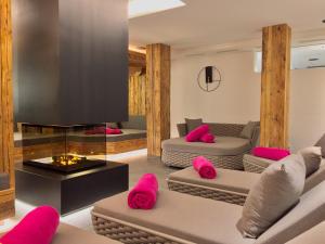 a living room with two couches and a fireplace at Hotel Stadt Wien in Zell am See