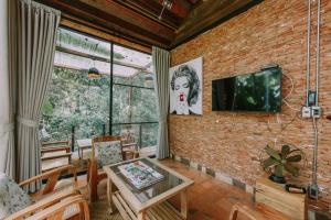 a living room with a tv on a brick wall at Voraman Hut in Chiang Mai
