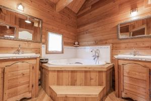 圣沙夫雷Chalet Hibou, large chalet with mountain views and close to slopes的木制浴室设有浴缸和两个盥洗盆