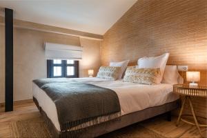 a bedroom with a large bed with a brick wall at MH Apartments Central Sevilla in Seville