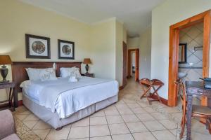 a bedroom with a large white bed in a room at Croc River Lodge in Komatipoort