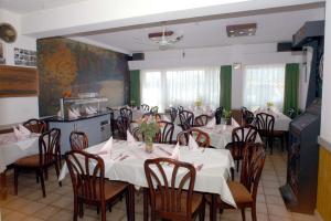 a dining room with white tables and chairs with flowers on them at Hotel Terminus in Mainz