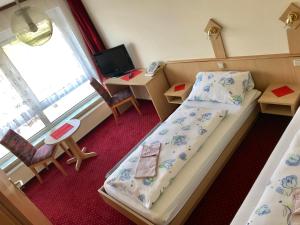 a bedroom with a bed and a desk and a television at Hotel Terminus in Mainz