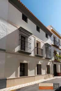 a white building with black barred windows at MH Apartments Central Sevilla in Seville