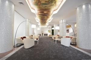 a lobby with white chairs and a painting on the ceiling at Hotel Excelsior San Marco in Bergamo