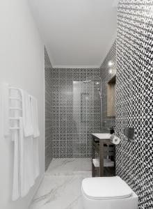 a bathroom with a white toilet and a shower at The Square Hotel in Cluj-Napoca