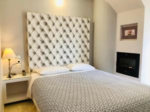 sypialnia z dużym łóżkiem z dużym zagłówkiem w obiekcie Lovely Apartments w mieście Patras