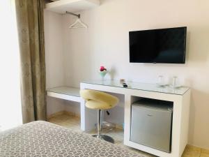 a bedroom with a desk with a television and a chair at Lovely Apartments in Patra