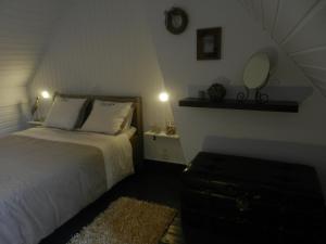 Schlafzimmer mit einem Bett und einem Wandspiegel in der Unterkunft Holiday Home Juliette in Poperinge