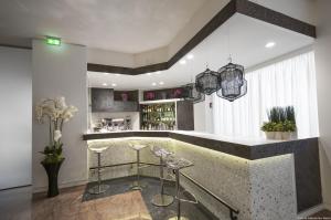 uma cozinha com um bar com bancos em Hotel Excelsior San Marco em Bérgamo
