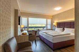 Habitación de hotel con cama grande y ventana en Sporthotel Grünberg, en Grünberg