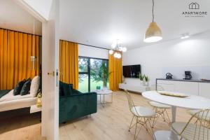 a living room with a couch and a table at Rezydencja Wintera by Apartmore in Gdańsk
