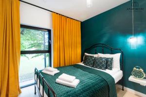 a bedroom with a green bed and a window at Rezydencja Wintera by Apartmore in Gdańsk