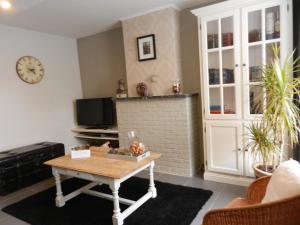 ein Wohnzimmer mit einem Tisch und einem Kamin in der Unterkunft Holiday Home Juliette in Poperinge