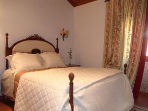 um quarto com uma cama com um edredom branco em Casa Santa Catarina em Penha Garcia
