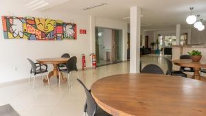 a dining room with tables and chairs and a painting on the wall at Hotel Skalla in Teixeira de Freitas