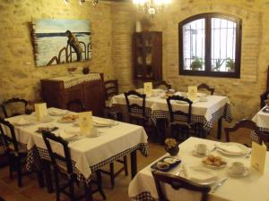 a dining room with tables and chairs with white table cloth at Hostal La Panavera in Perelló