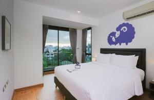 Kokotel Bangkok Sukhumvit 50 - SHA Extra Plus tesisinde bir odada yatak veya yataklar