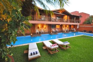 um resort com uma piscina com espreguiçadeiras em Villa Floreal Hotel Boutique em Assunção
