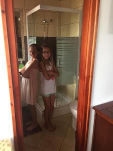 シャールヴァールにあるCherry Apartmanházの二人の女の子がシャワー付きのバスルームに立っている