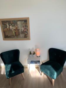 two green chairs and a table in a room at De Maecht van Mechelen in Zierikzee