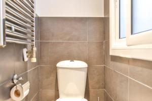 a bathroom with a toilet and a window at Ghat Apartments Montroig in Sitges