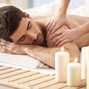 Ein Mann bekommt eine Massage in einem Spa mit Kerzen in der Unterkunft Zen Pousada in Telêmaco Borba