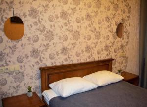 1 dormitorio con cama y pared con papel pintado en Bogdanov Yar Hotel, en Kiev