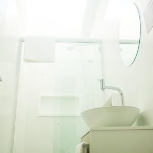 a white bathroom with a sink and a mirror at Zen Pousada in Telêmaco Borba +24 photos