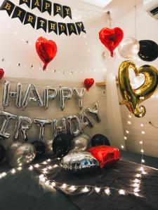 a room with balloons and a happy anniversary sign at Lighthouse Homestay Vũng Tàu in Vung Tau